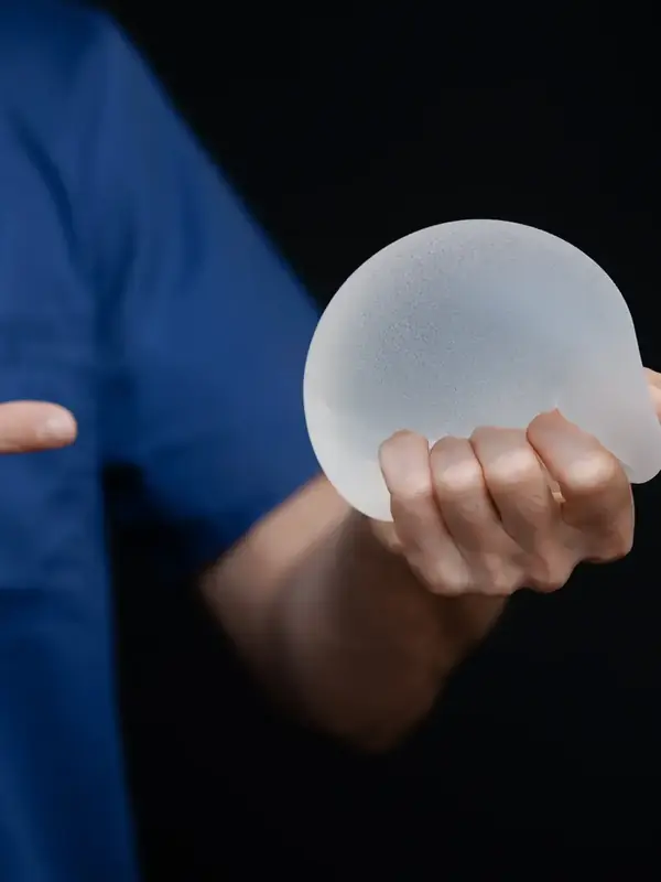 Surgeon holding a breast implant during a consultation